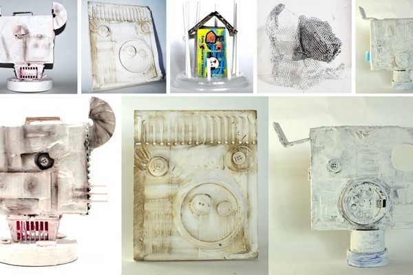 Collection of student-made sculptures and reliefs using recycled materials and white paint.