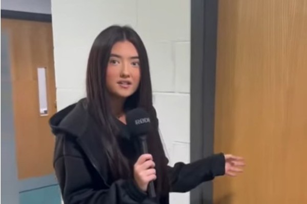 A beauty student holding a microphone and introducing the creative beauty class at Glasgow Kelvin College.