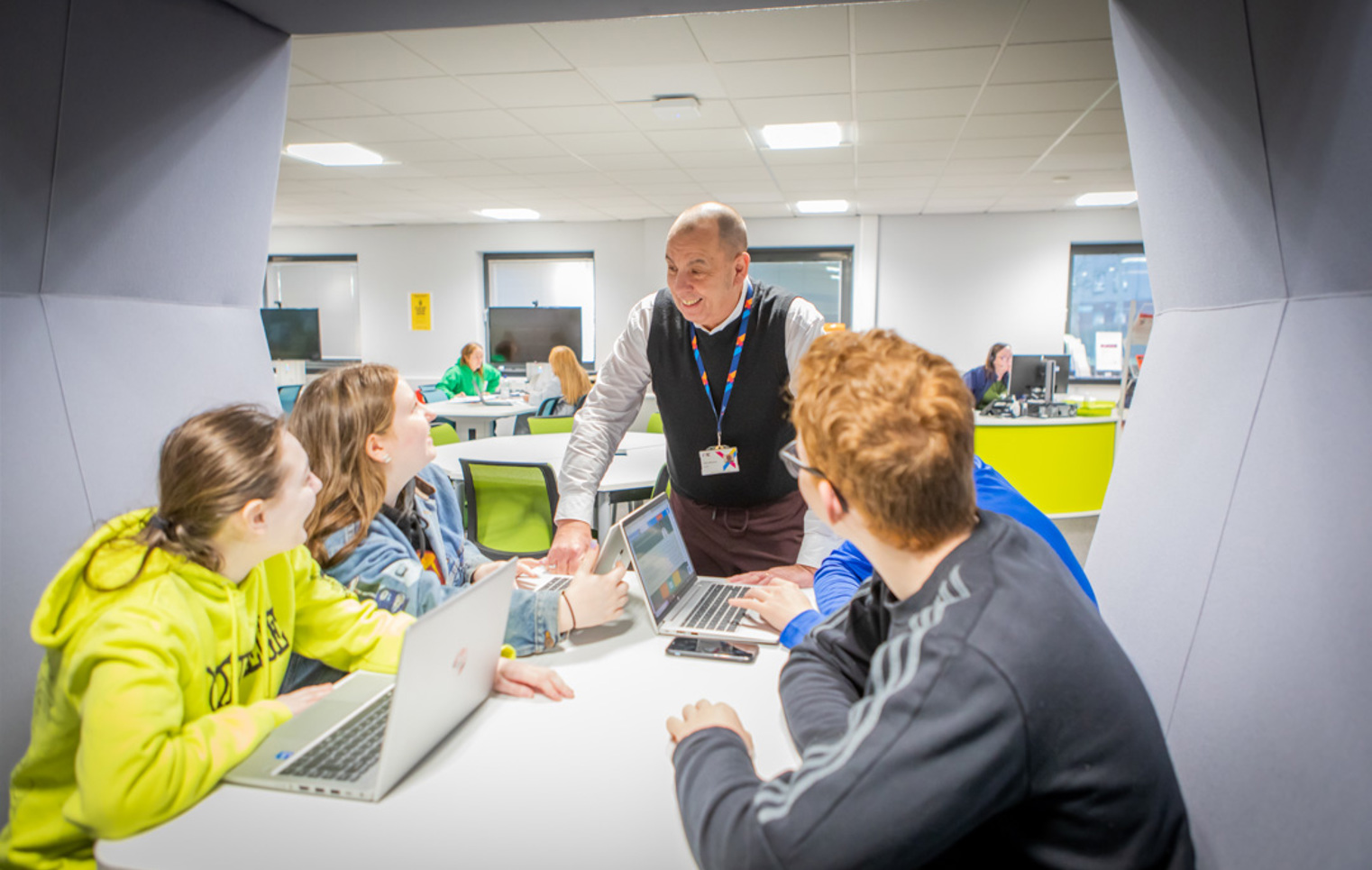 Staff member supporting students during a group study session in the Easterhouse Flexible Learning Centre at Glasgow Kelvin College.