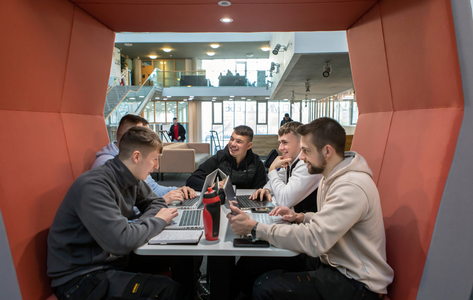 Group of students working together on laptops in a study pod at Glasgow Kelvin College’s Springburn campus.