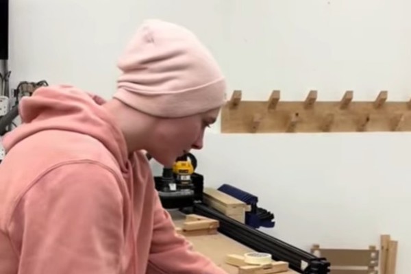 Rachael, Women into Construction student, measuring timber with a handsaw in a workshop at Glasgow Kelvin College.