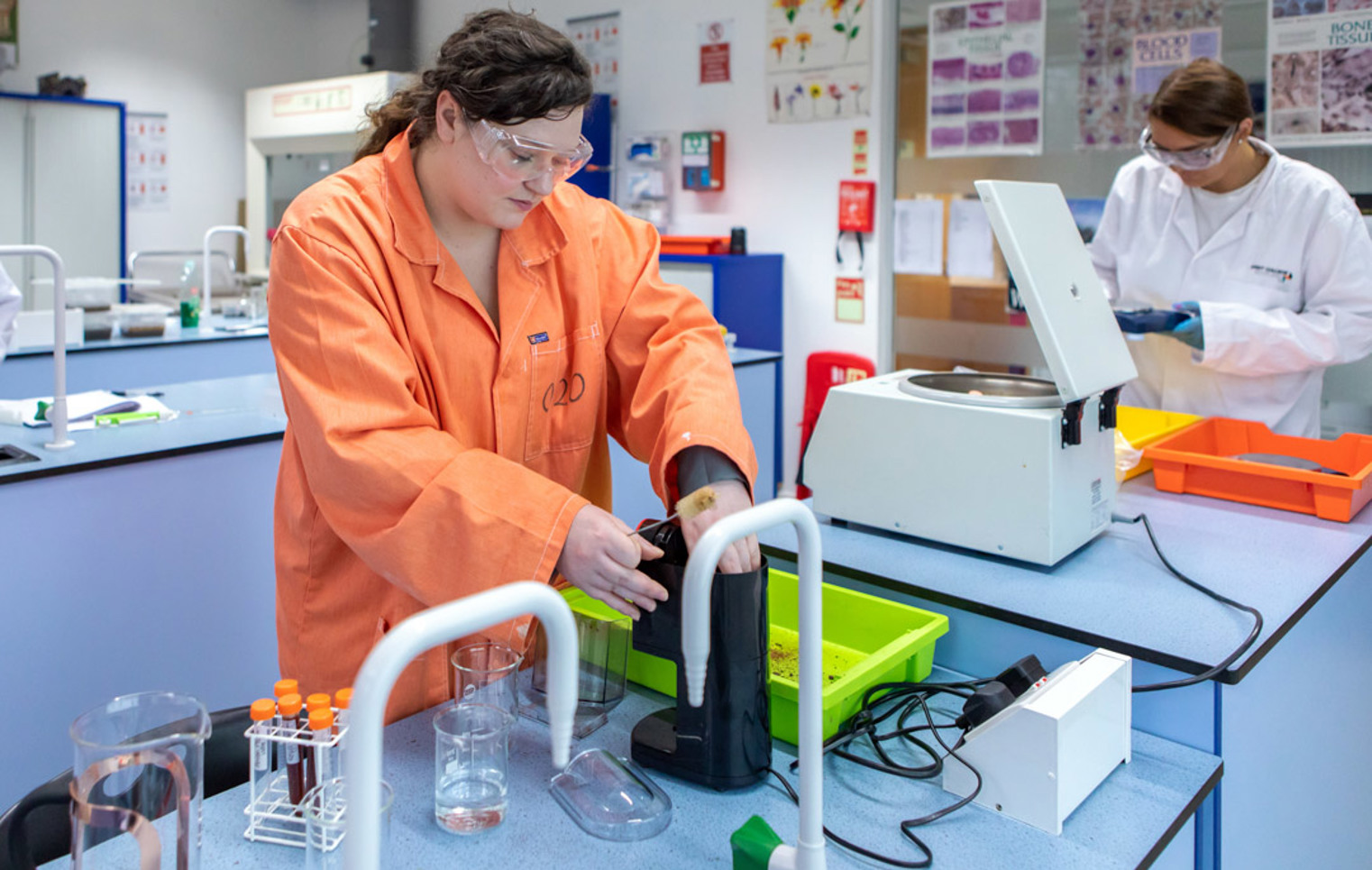 Student using lab equipment with centrifuge in science lab during practical session