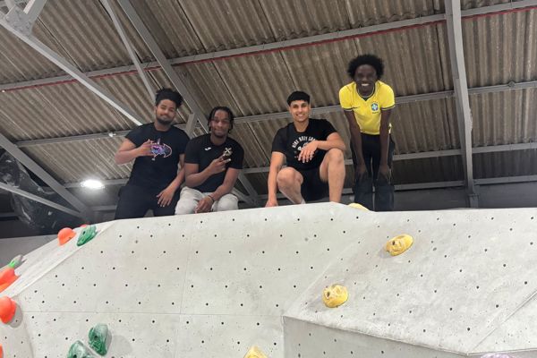 ESOL students standing on top of an indoor climbing wall during a group visit.