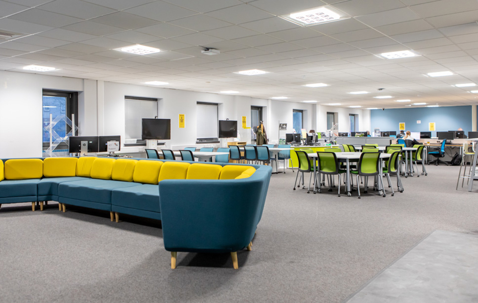  Bright and modern library and flexible learning centre at Glasgow Kelvin College Easterhouse Campus, featuring computers, group tables, and colourful seating.