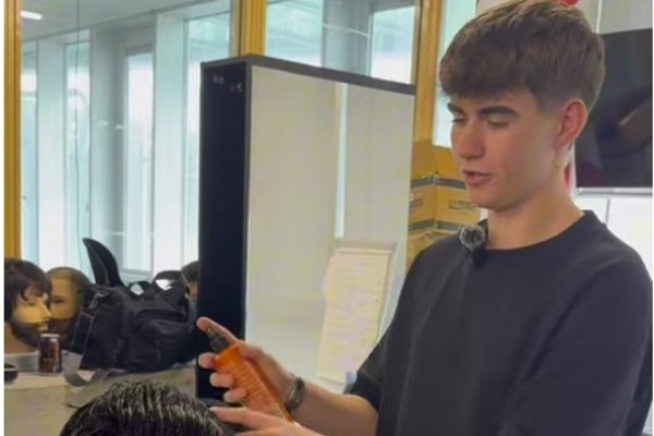 Hairdressing student Marcus demonstrates how to cut and style a modern mullet on a training mannequin at Glasgow Kelvin College.