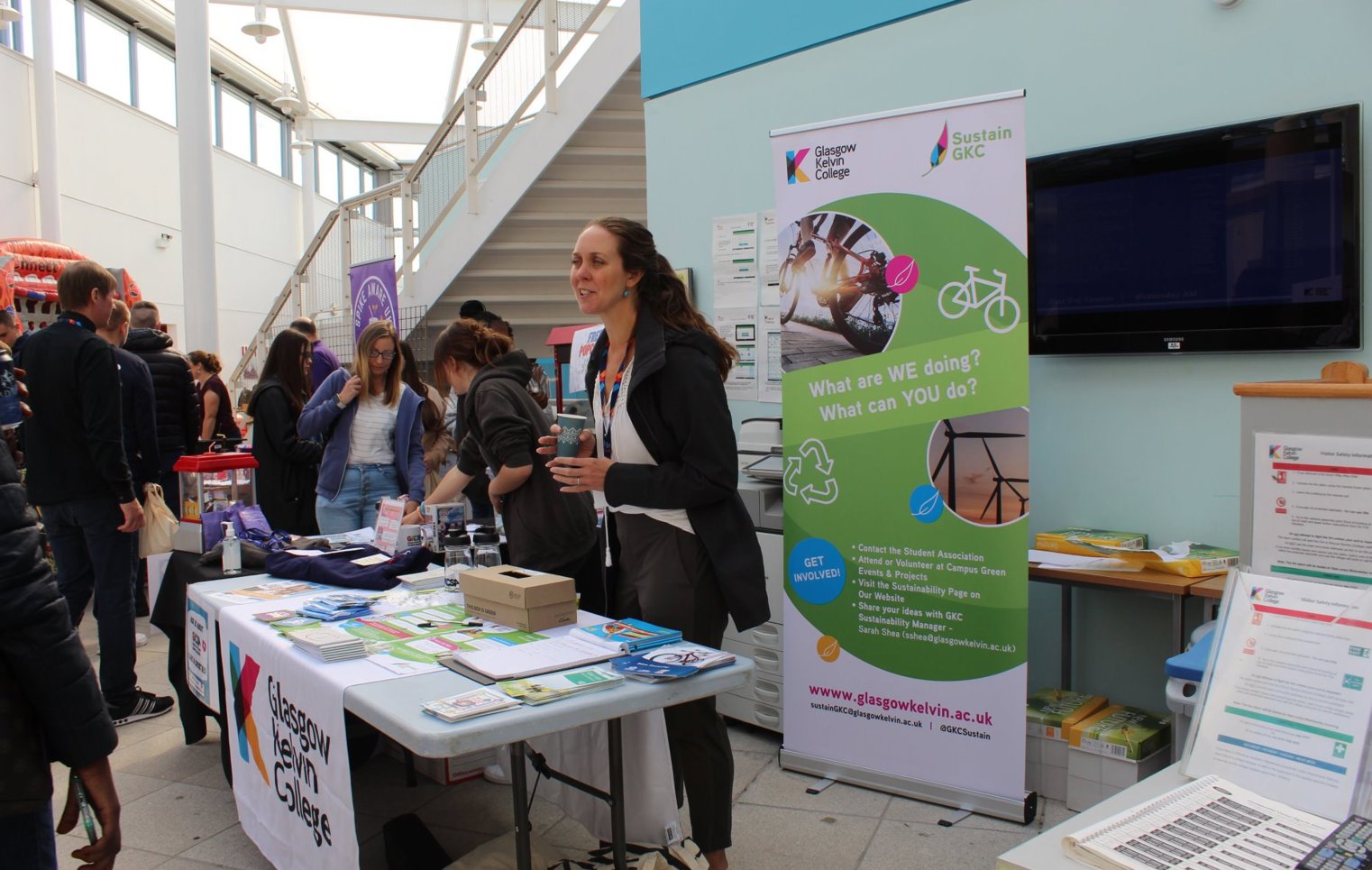 Glasgow Kelvin College sustainability stall at Freshers’ Week, featuring a banner, leaflets, and staff engaging with students about green initiatives.