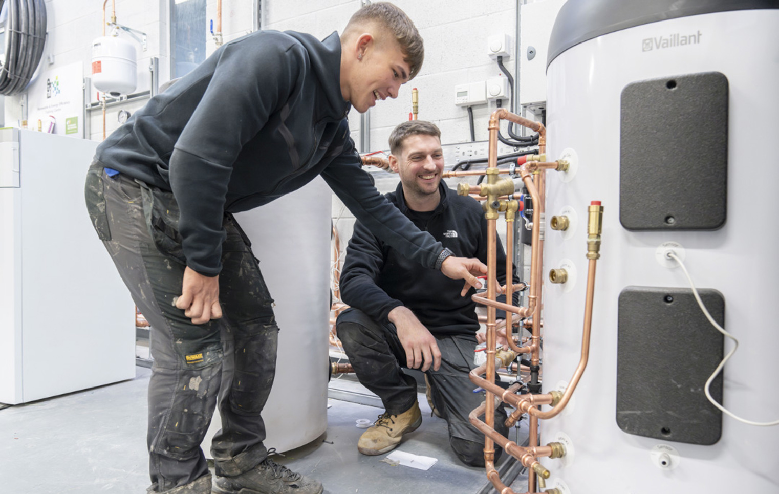 Student working on a plumbing installation board with copper pipes at Glasgow Kelvin College as part of the Green Academy training programme.