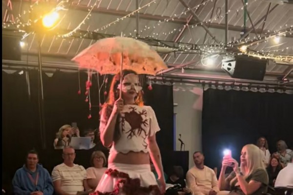 Model wearing a theatrical white and red costume while walking the runway during Glasgow Kelvin College’s Fashion Show 2026 event.