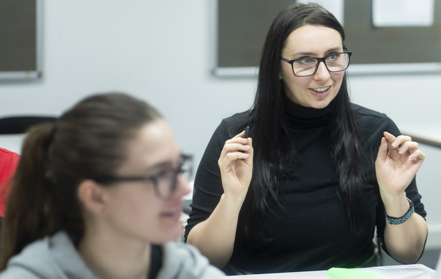 Student raises a point during an engaging discussion in a classroom setting.