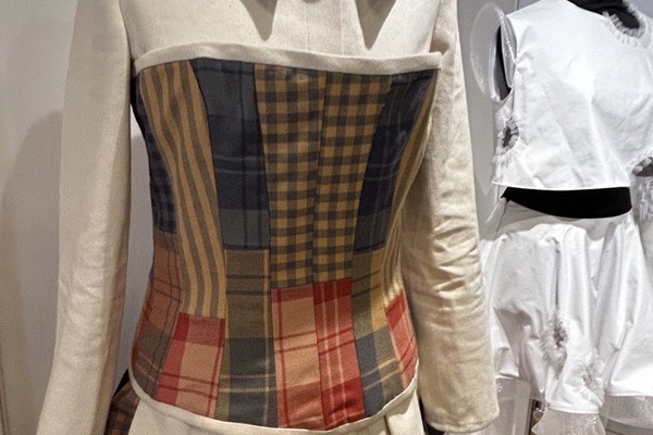 A cream jacket with a colourful tartan patchwork bodice and layered ruffle skirt, part of an upcycled fashion design on display at Craftex 2025