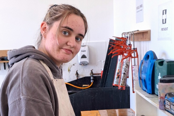 Art student using a roller to apply ink during a printmaking session at Glasgow Kelvin College