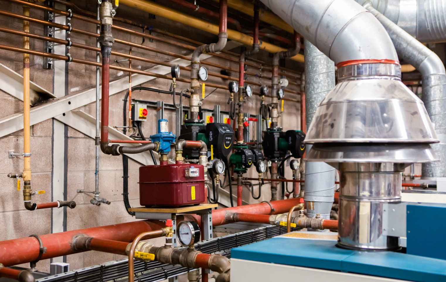 Building services training equipment including pipes, valves and heating systems in a college workshop.