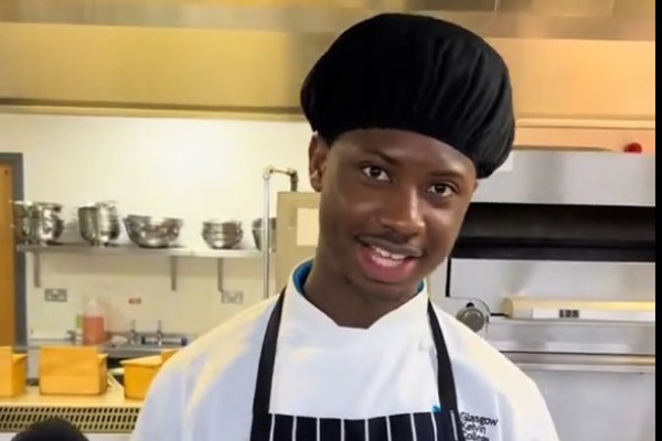 Hospitality student Mohammad speaking into a microphone while standing in a professional training kitchen at Glasgow Kelvin College.