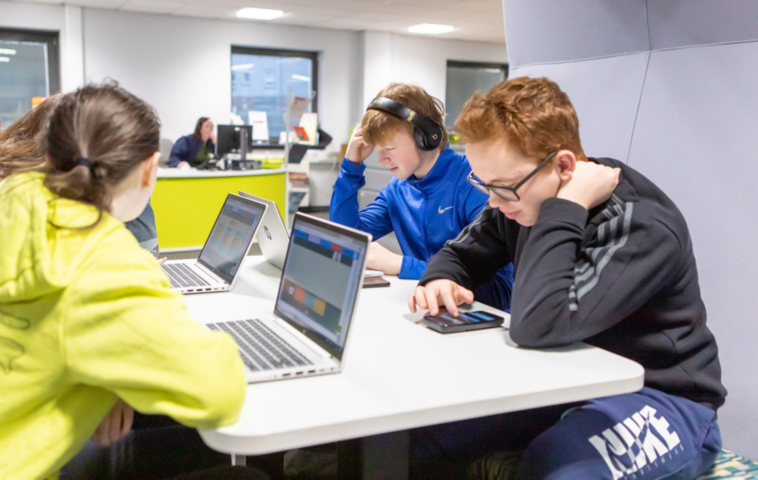 Group of students working on laptops and mobile devices in the Library and Flexible Learning Centre at Glasgow Kelvin College’s Easterhouse Campus.