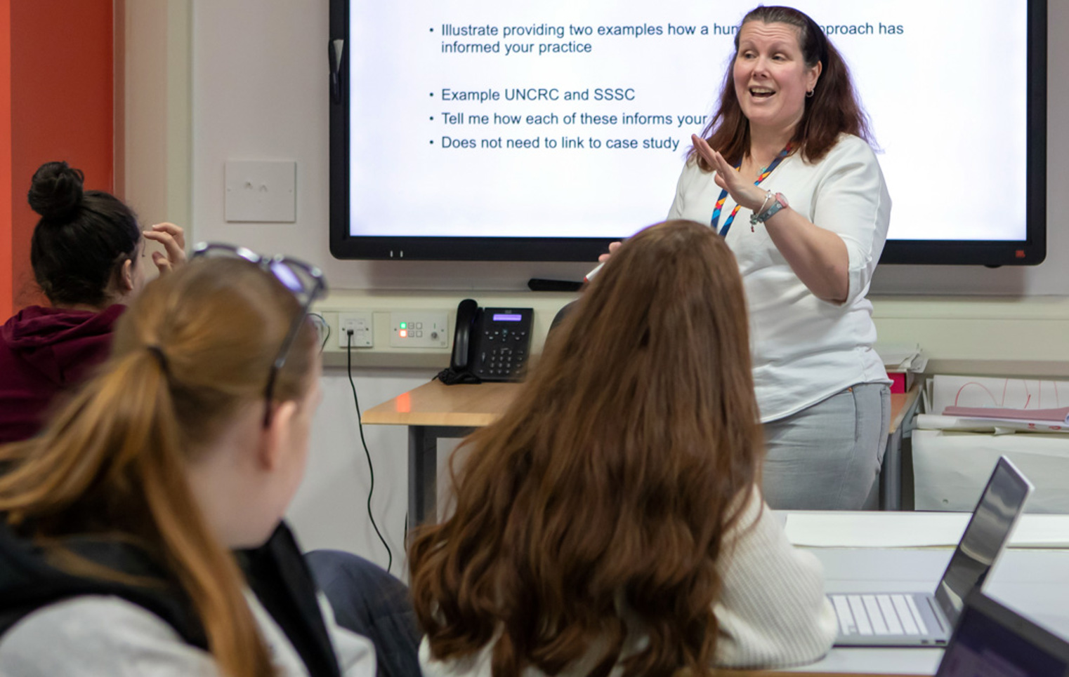 Students fully engaged in an interactive lesson at Glasgow Kelvin College, led by their enthusiastic lecturer encouraging lively classroom discussion.