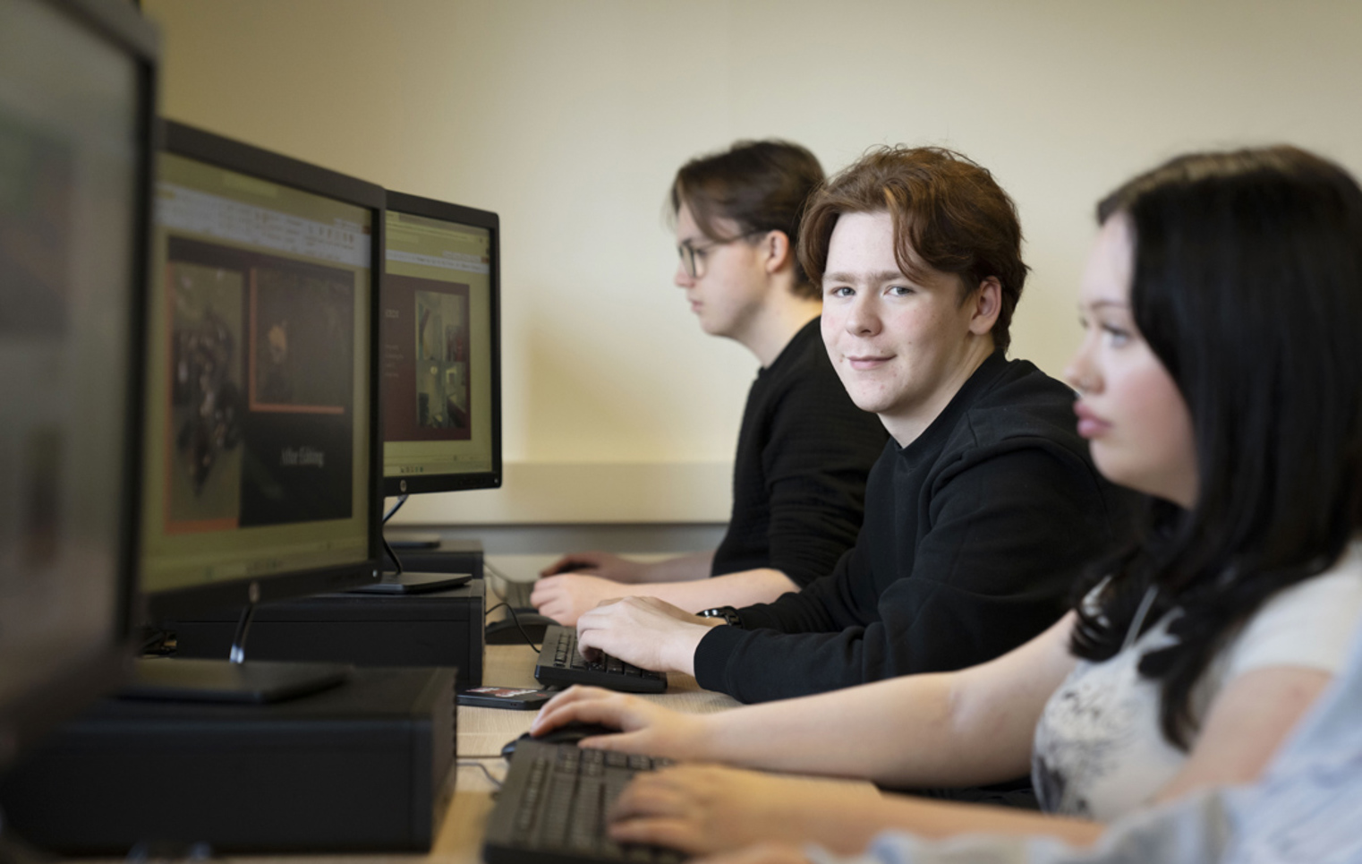 Student seated at a computer workstation during a digital media lesson at Glasgow Kelvin College.