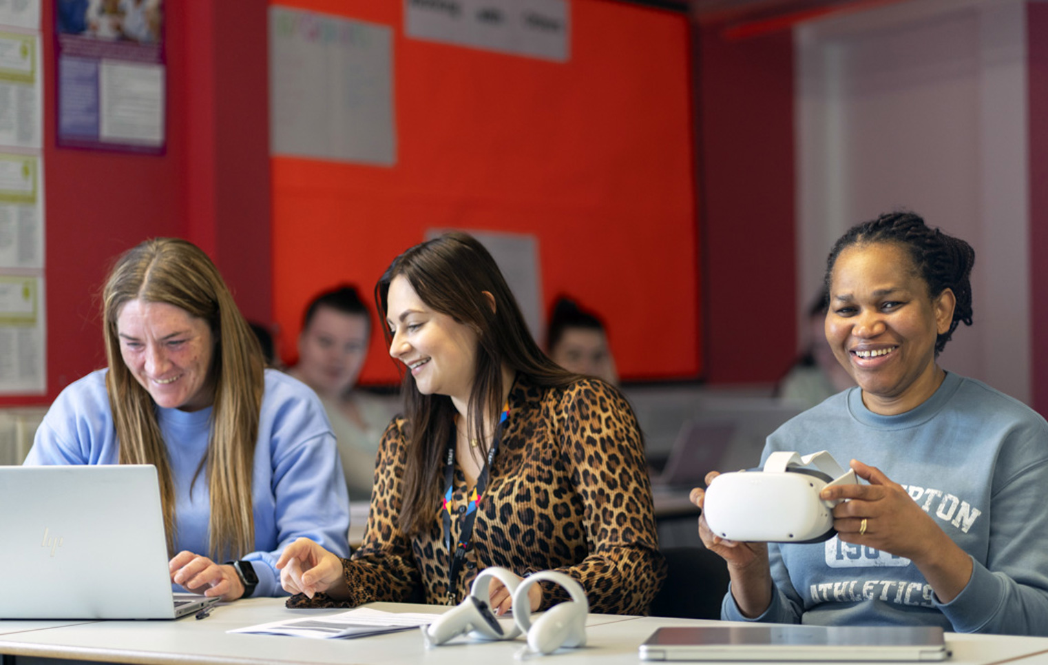 Students and staff seated at tables with laptops and virtual reality equipment during a learning session at Glasgow Kelvin College.