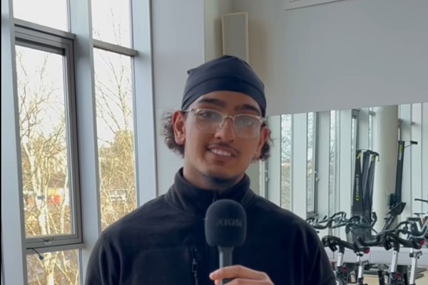 Sport and Fitness student holding microphone and speaking in gym facility at Glasgow Kelvin College.
