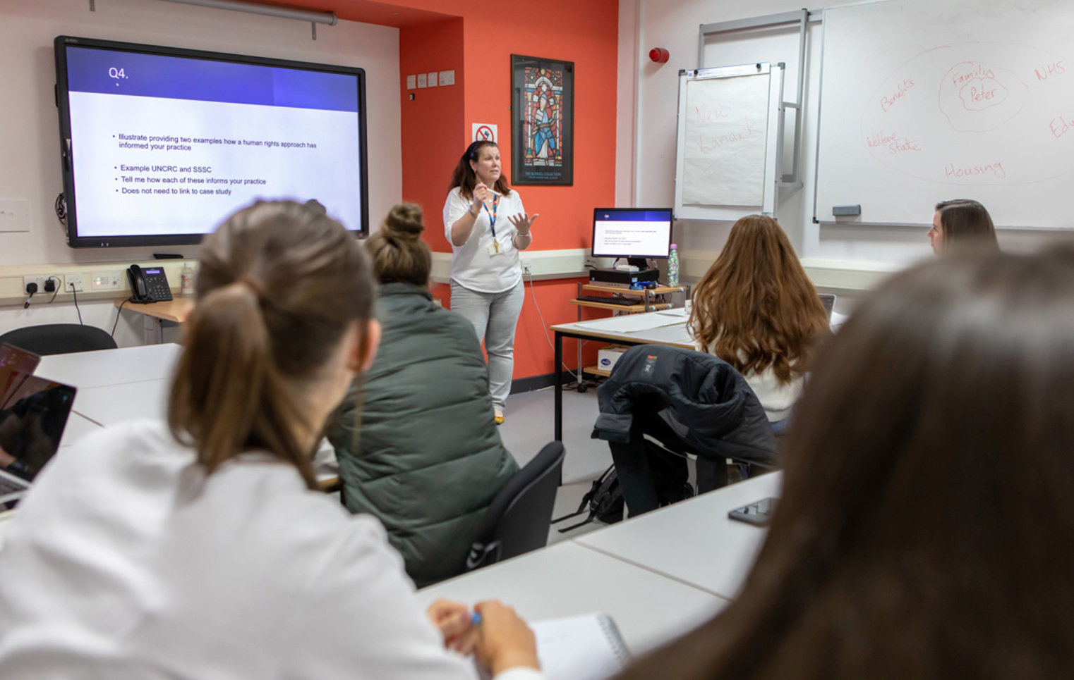 Glasgow Kelvin College students actively participating in class, guided by their lecturer through interactive discussions and activities.