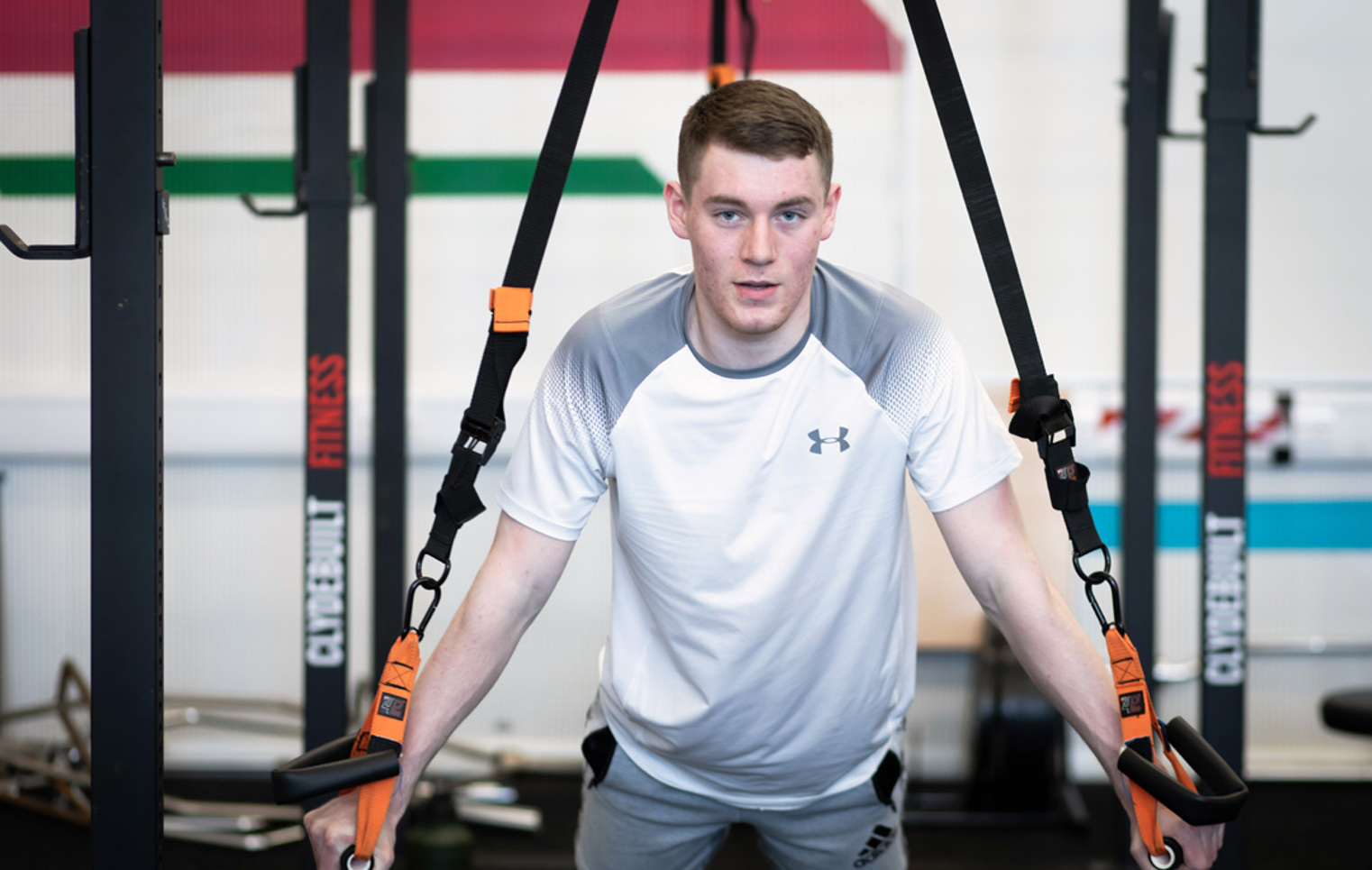 Focused man performing suspension push-ups with TRX straps.