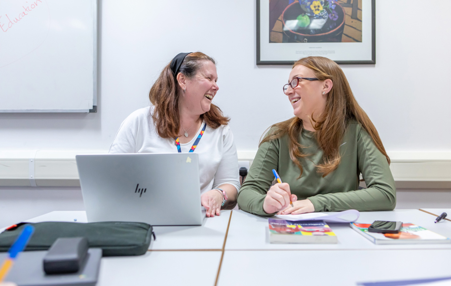 A cheerful moment between lecturer and student at Glasgow Kelvin College, showcasing supportive relationships and engaging one-to-one learning.