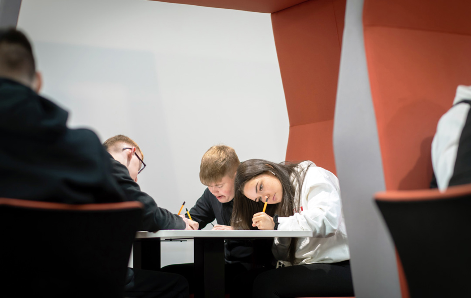 Students gathered in a pod seating area at Glasgow Kelvin College’s Springburn Campus, working collaboratively with laptops and study materials.